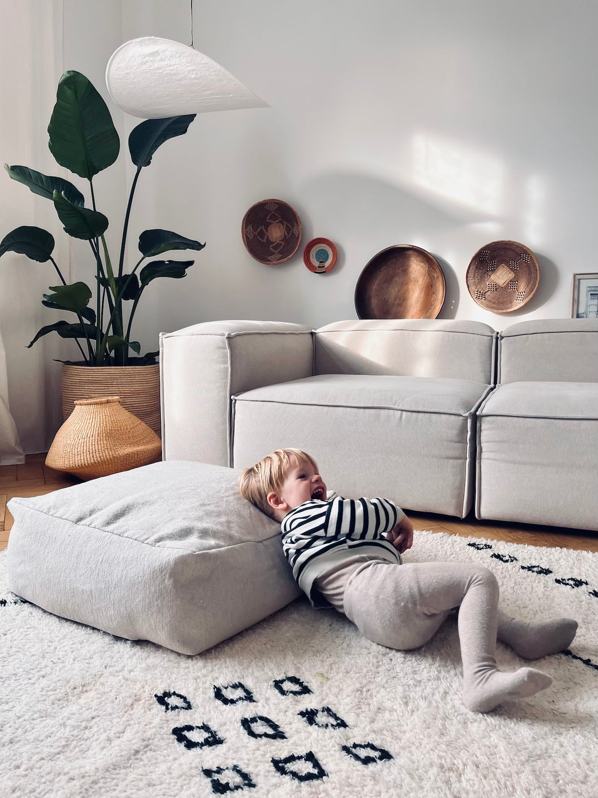 Bodenkissen auf weißem kuschligen Teppich in Wohnzimmer einer Altbauwohnung 