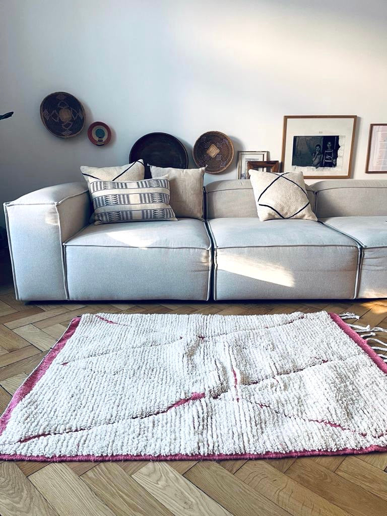 Beni Ouarin Teppich vor Sofa. Kuschliger Berberteppich aus Schurwolle für die Wohnzimmer oder Kinderzimmereinrichtung. 