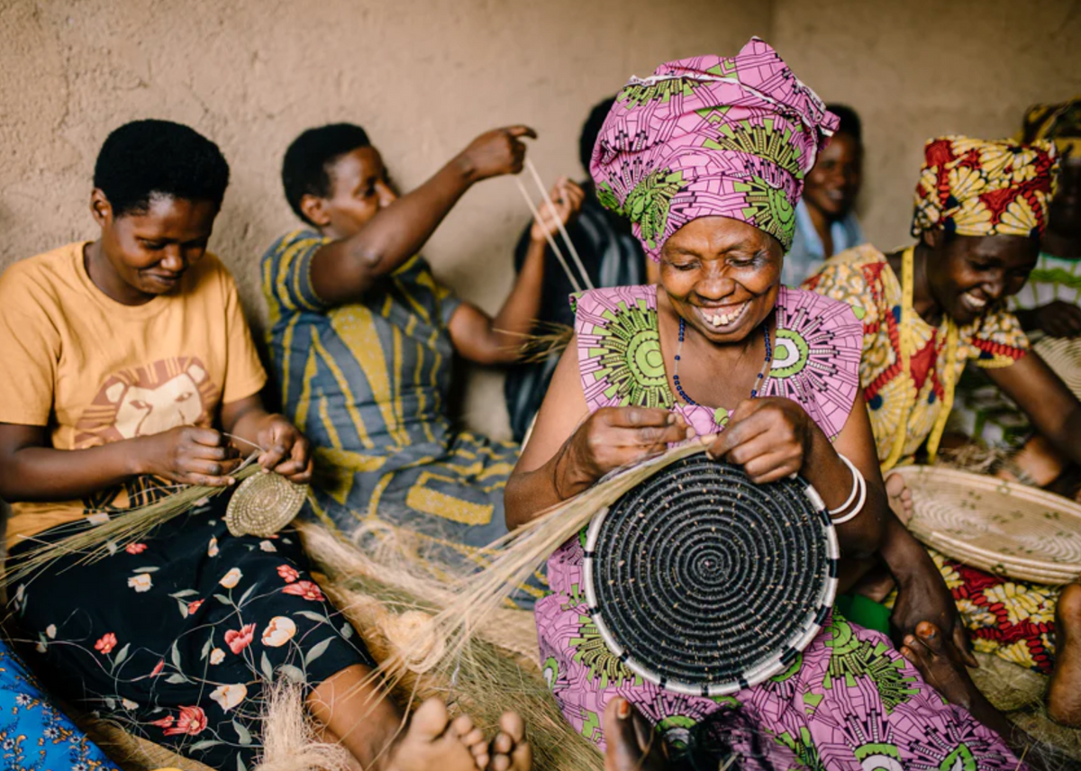 Frauen in einem afrikanischen fair trade Projekt beim herstellen von Korbwaren. 