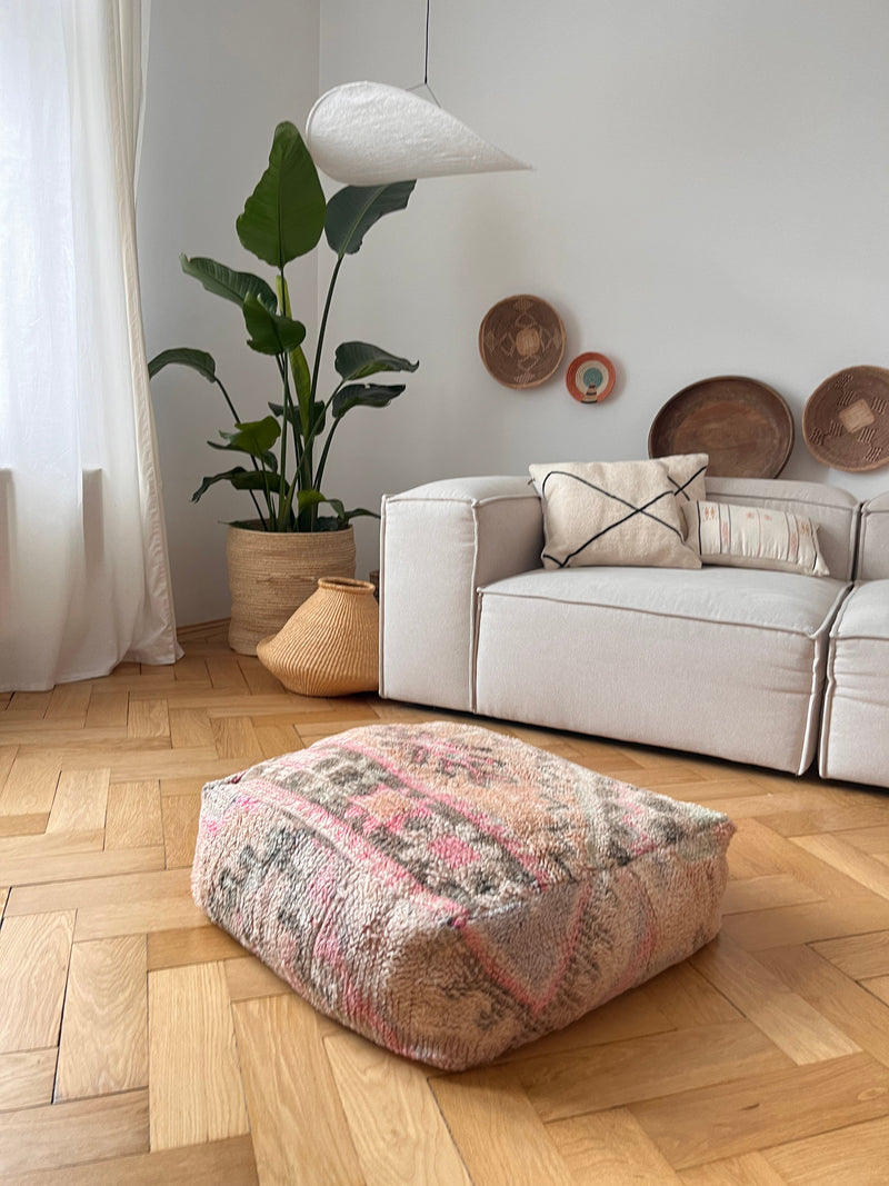 Bodenkissen vor Sofa im Wohnzimmer auf Holzparkett