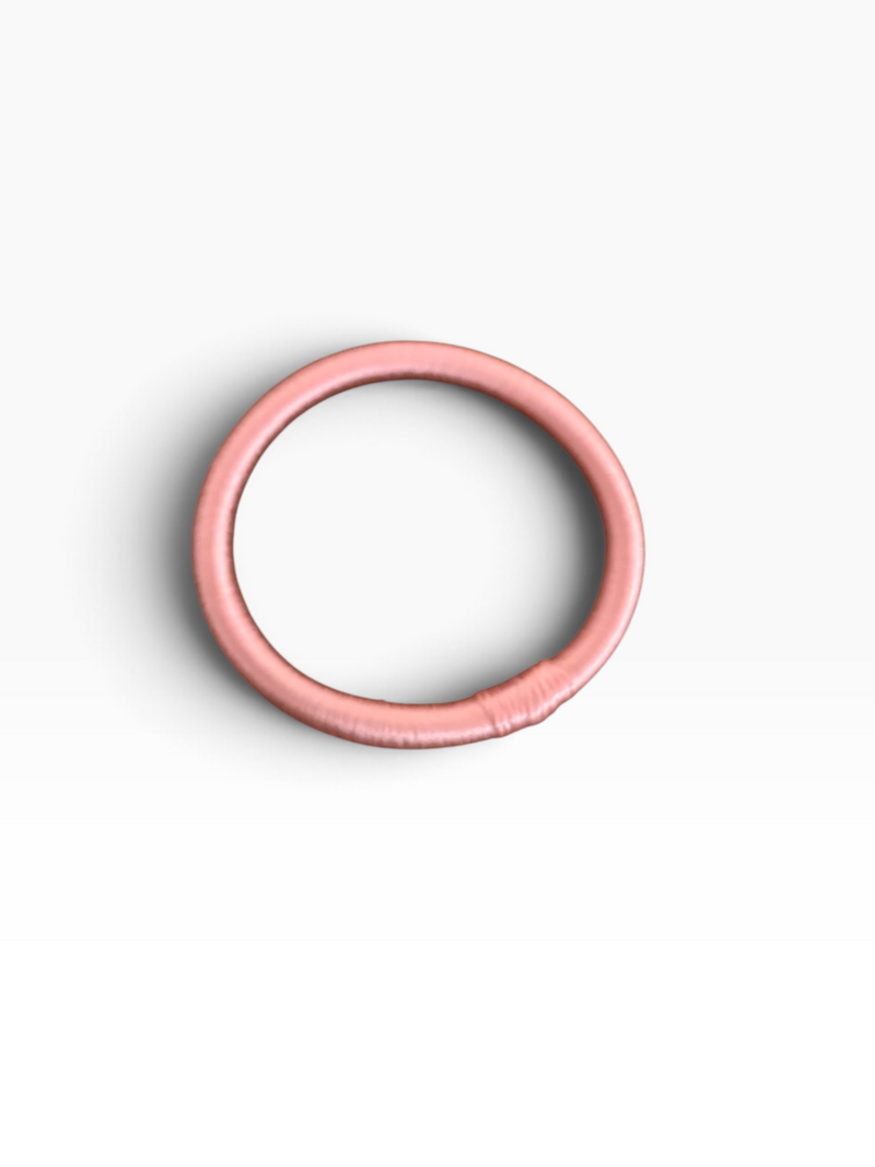 Der LEY! Armreif „Minama – Rosa-Pink“ setzt einen eleganten Farbakzent und windet sich kreisförmig auf weißem Hintergrund.