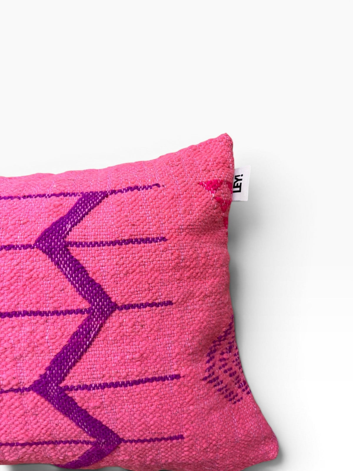 LEY! - Kissen - Colorful Line - PINK EDITION zeigt lilafarbene Zickzacklinien, die sich teilweise von einem weißen Hintergrund abheben.
