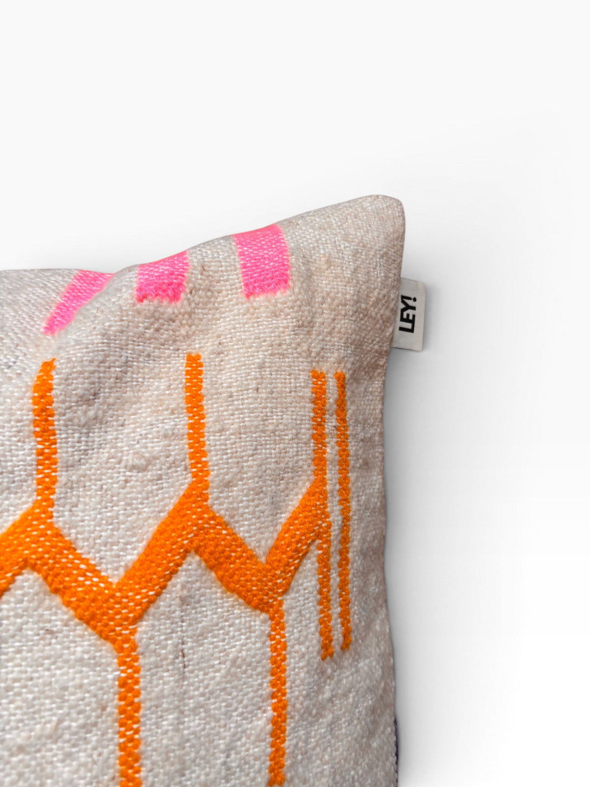 Das LEY! Kissen - Colorful Line 60x60 von LEY! besteht aus beigem Stoff mit geometrischen Mustern in Orange und Rosa.