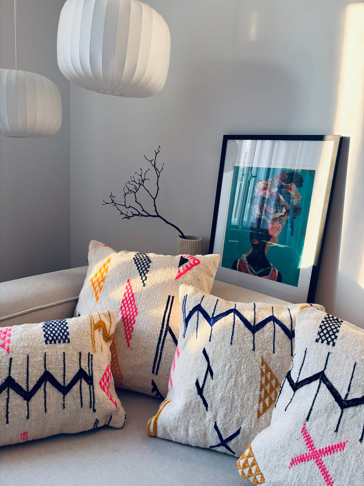 Vier cremefarbene LEY! Kissen – Colorful Line – 50 x 50 Kissen mit geometrischen Mustern, die auf einem Sofa angeordnet sind.