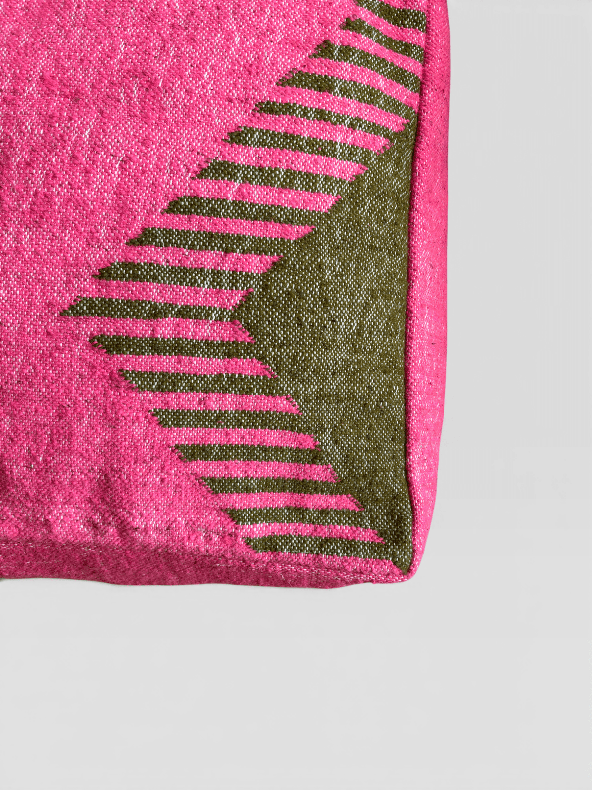 Das LEY! Bodenkissen – Colorful Line – Amira besteht aus rosa Stoff mit grünen und rosa Streifen an einer Ecke.