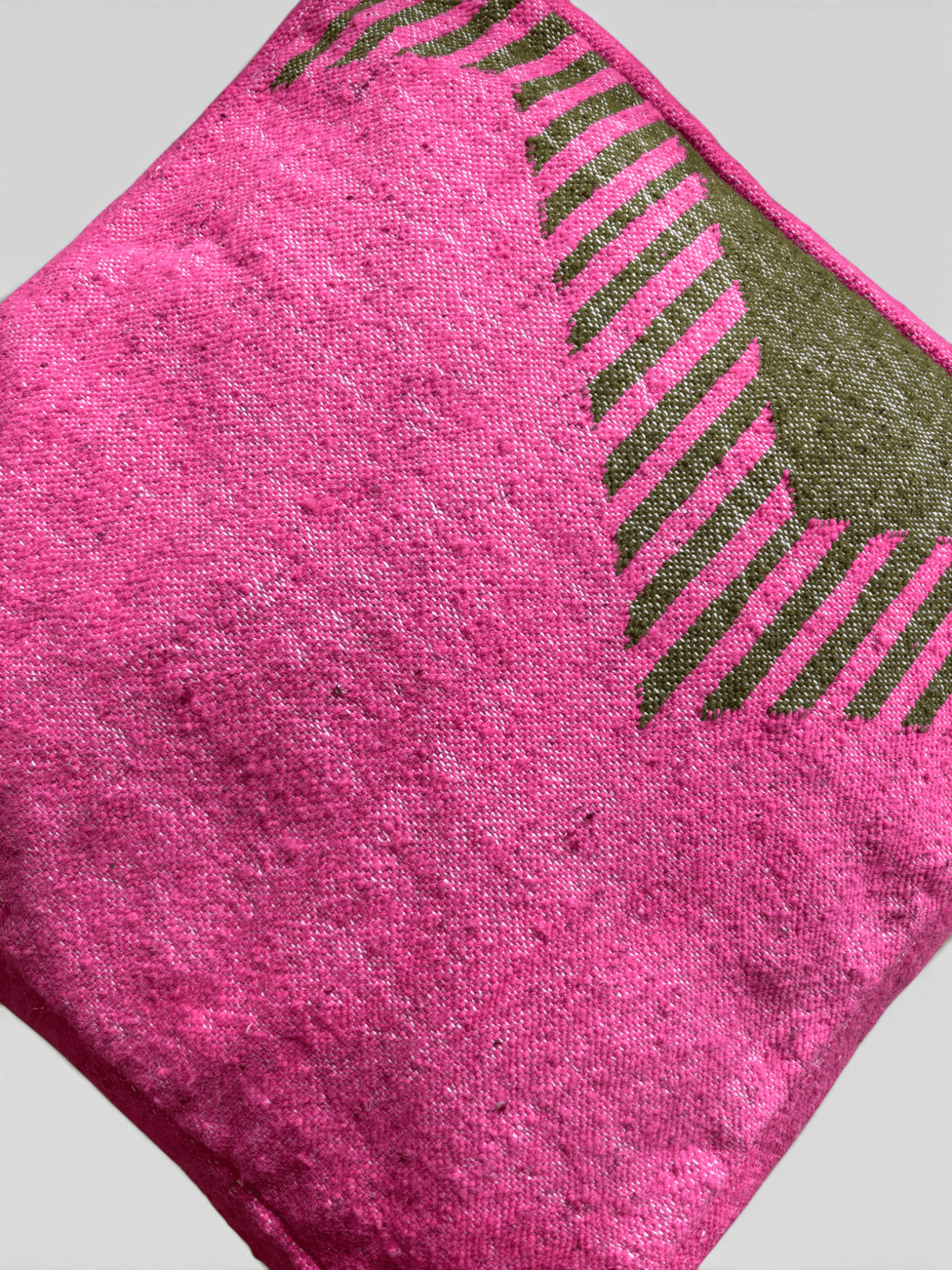 Das LEY! Bodenkissen – Colorful Line – Amira ist ein quadratisches, rosa Bodenkissen mit einem grünen geometrischen Motiv in einer Ecke.