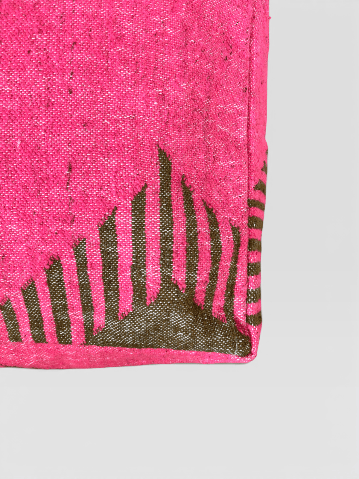 Eine Ecke der LEY! Bodenkissen-Kollektion „Colorful Line – Relana“ zeigt ein rosa Kissen mit schwarzen Streifen und Pfeilmuster auf hellem Hintergrund.