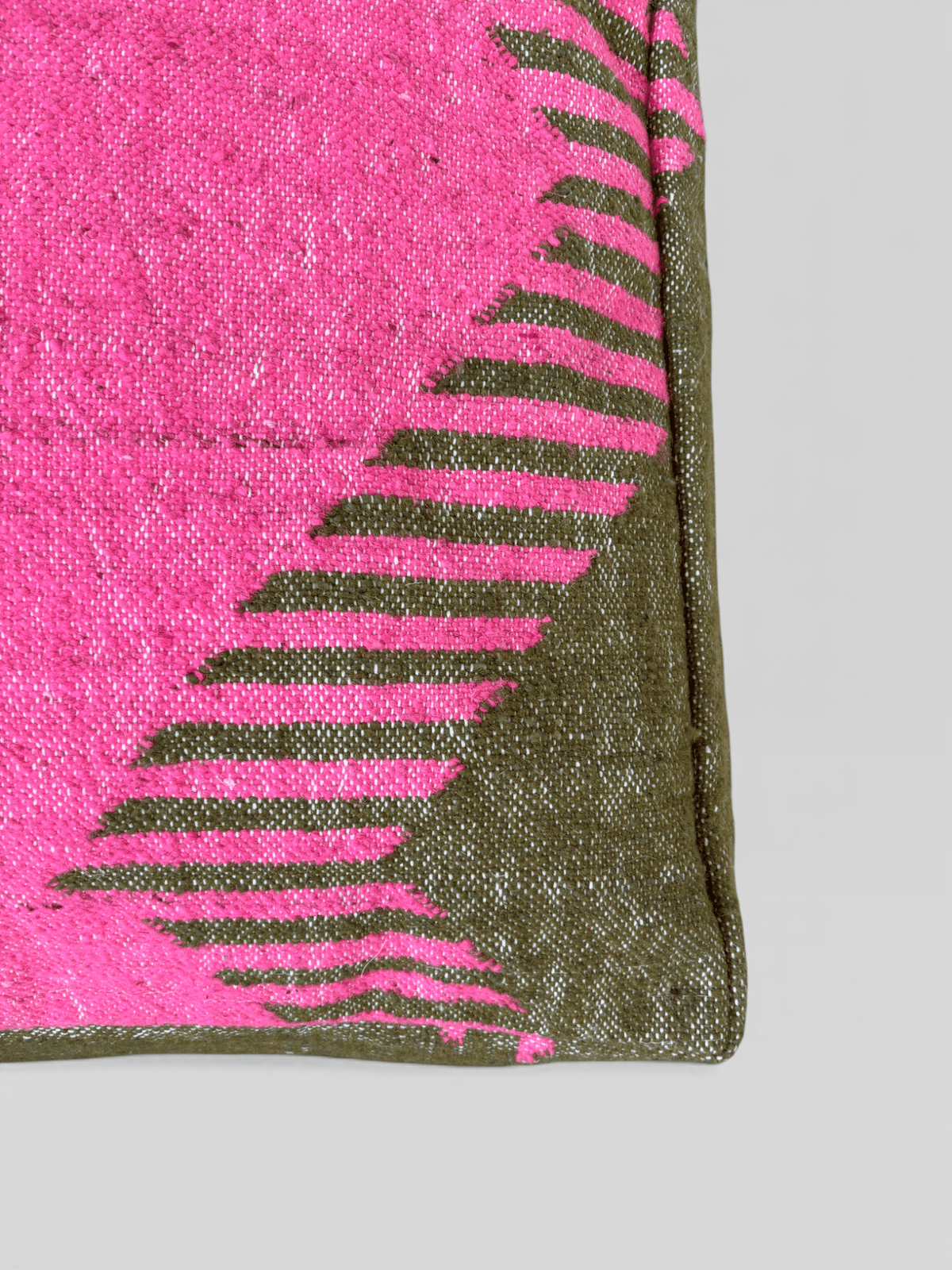 Nahaufnahme des Bodenkissens – „Colorful Line“ – „Molina“ von LEY!, mit rosa und olivgrünen Mustern, Eckkante abgebildet.