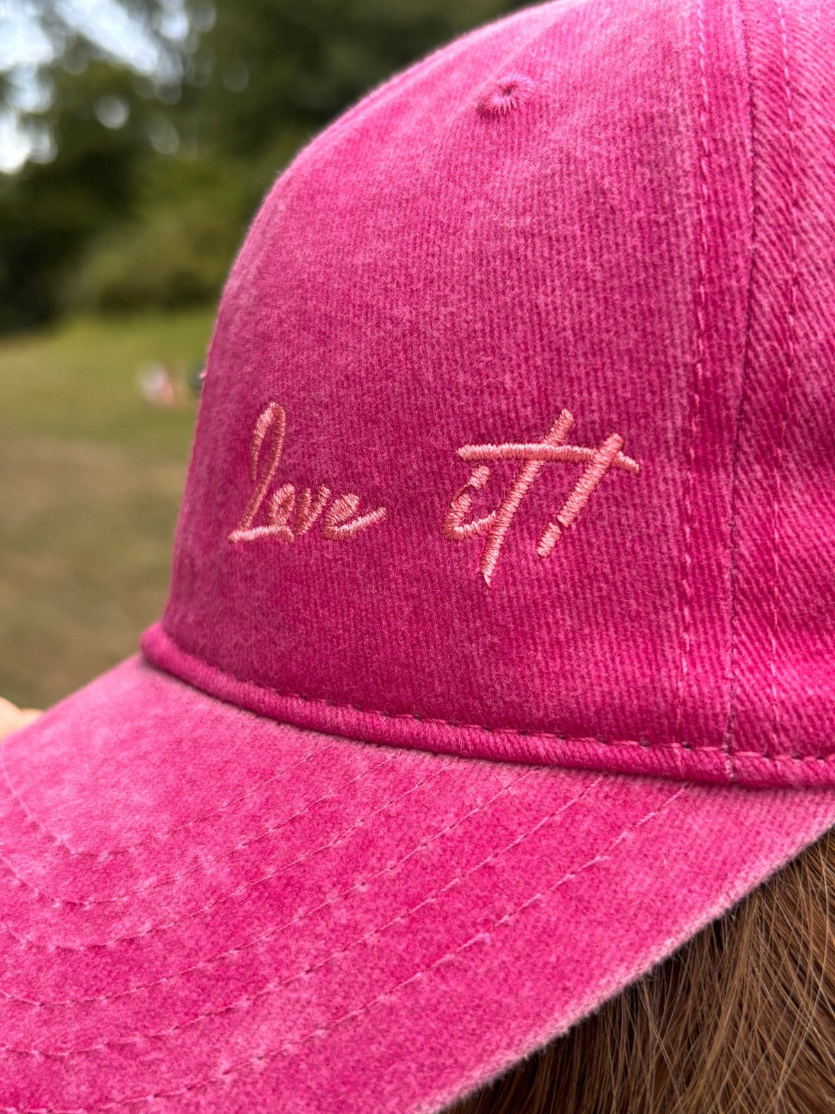 Nahaufnahme der grünen LEY! „Love it“-Kappe mit der Aufschrift „Love it!!“ in Schreibschrift auf der Vorderseite.