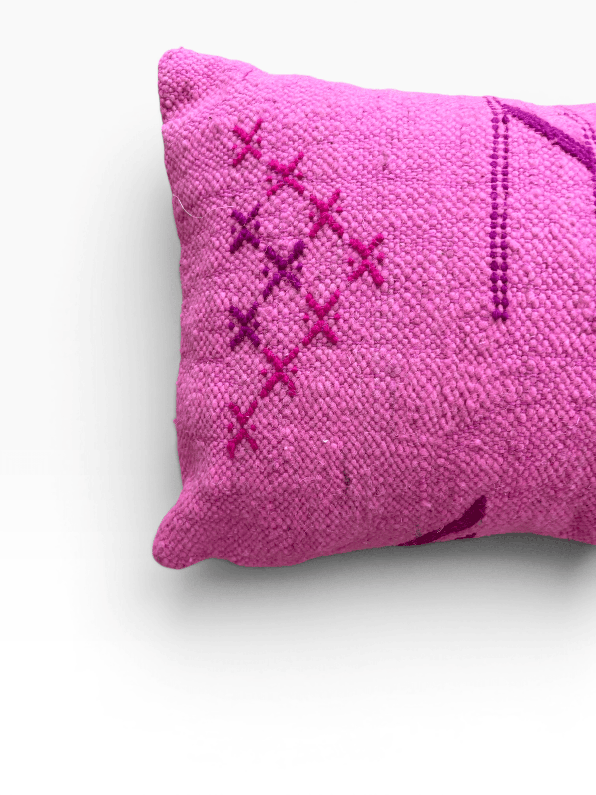 Das LEY! Kissen „Colorful Line Pink Edition“ (30 x 50) besticht durch violette Kreuzstiche auf rosa Stoff vor weißem Hintergrund.