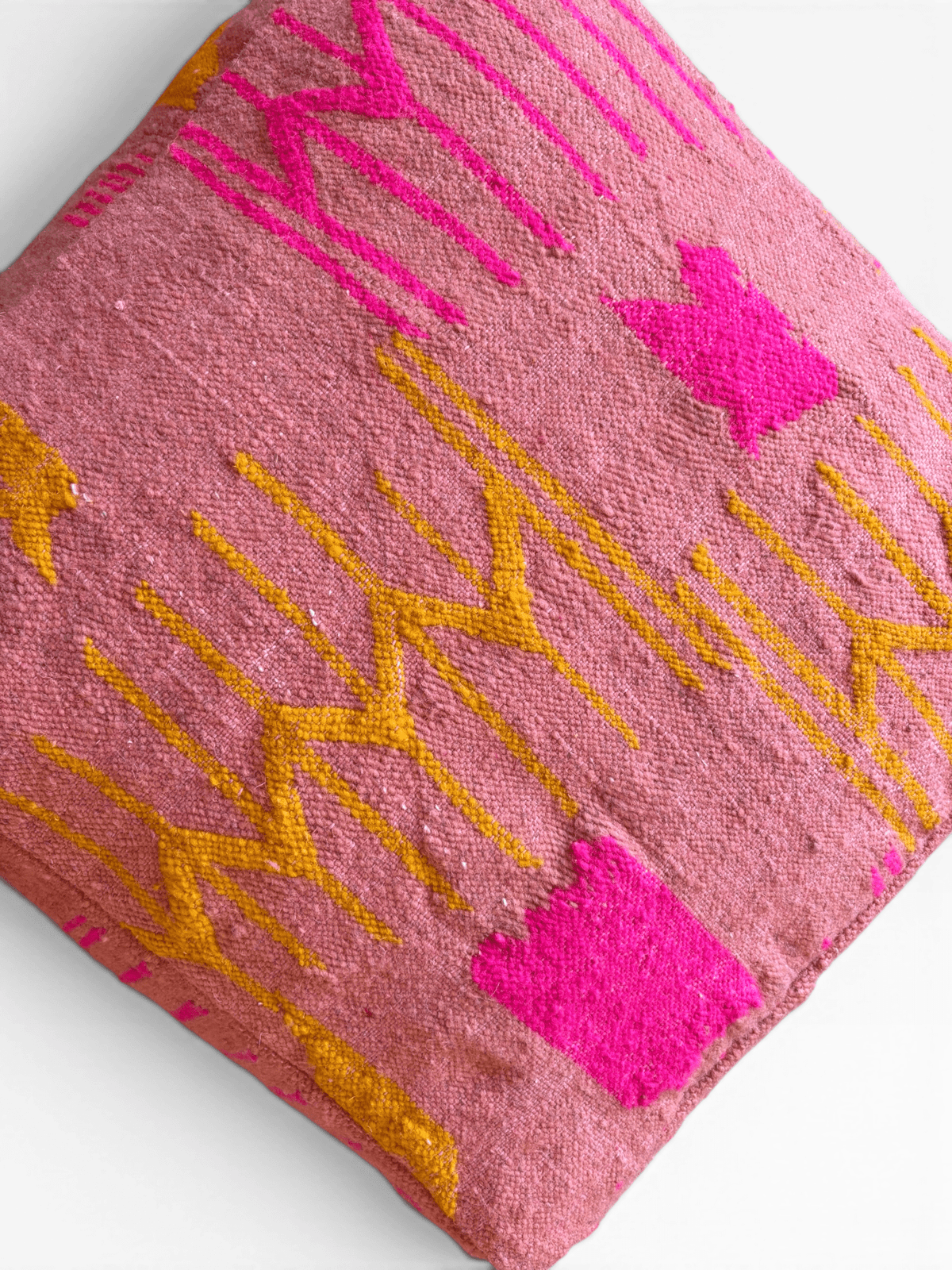LEY! Bodenkissen – Colorful Line Terra III: Quadratisches Kissen in Terrakotta mit rosa-gelben geometrischen Mustern auf strukturiertem Stoff.