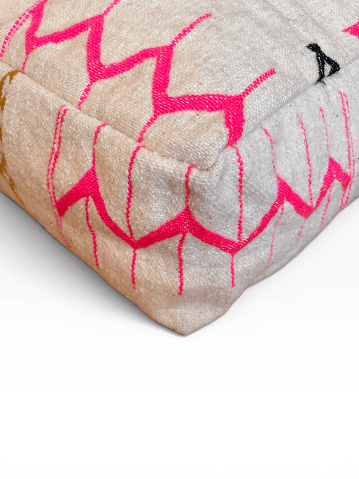Nahaufnahme des Bodenkissens von LEY! – „Colorful Line“ – „Kantia“, beige Wolle mit rosa geometrischen Ziernähten und einem schwarzen Akzent.