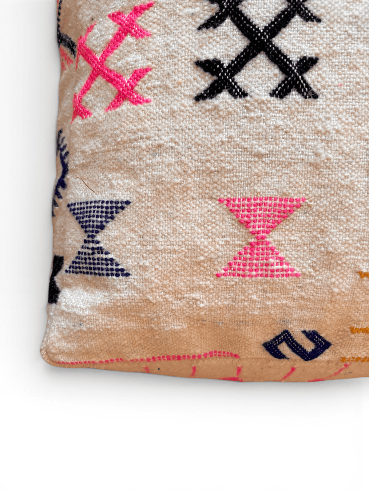 LEY! Bodenkissen – Colorful Line – Kantia: Beiges Boho-Kissen mit rosa, schwarzen und blauen geometrischen Stickereien auf gewebter Wolle.