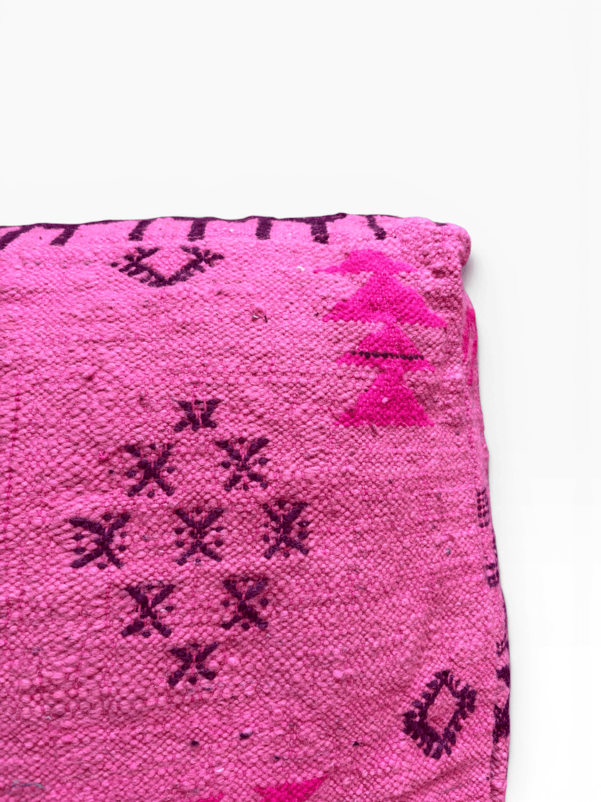 Nahaufnahme von LEY! Bodenkissen – Colorful Line – Pink Edition mit rosa Wolle sowie dunkelvioletten geometrischen Mustern und Baummotiven.