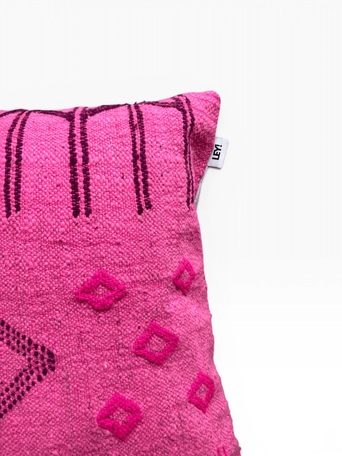 Ein LEY!-Kissen – Colorful Line – Pink Edition – Ein 50 x 50 Kissen mit dunklen Mustern vor einem schlichten weißen Hintergrund.