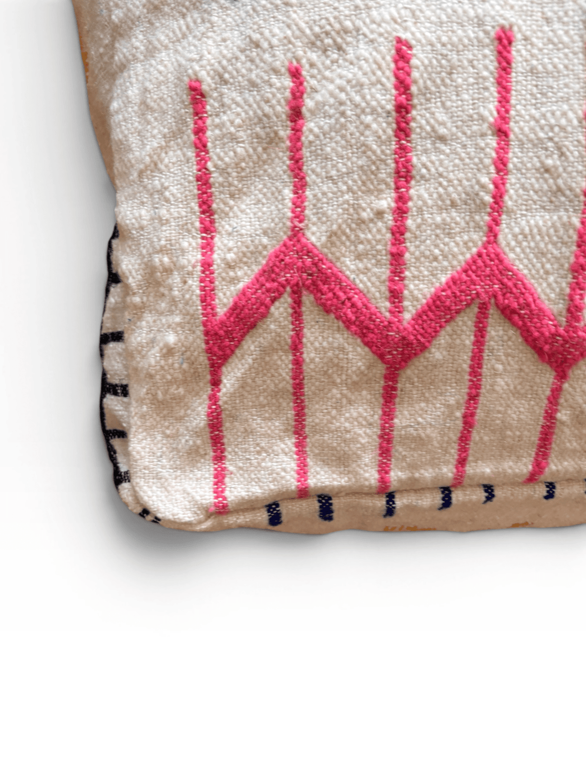 LEY! Bodenkissen – Colorful Line – Juni: Weißes Boho-Kissen mit rosa Zickzackmustern, schwarzen Nähten und weicher Wolle.
