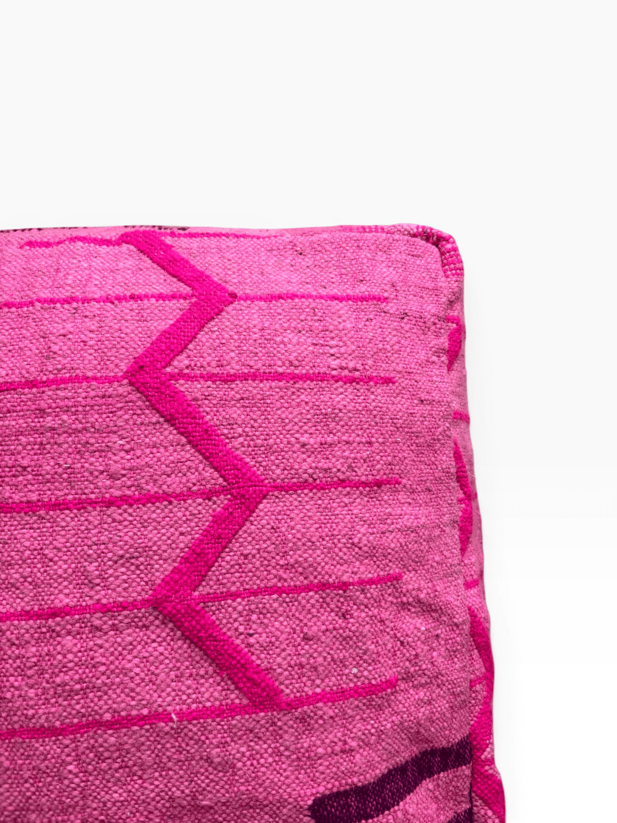 Eine Nahaufnahme des Kissens „LEY! Bodenkissen – Colorful Line – Pink Edition“ mit Zickzackmustern auf weißem Hintergrund.
