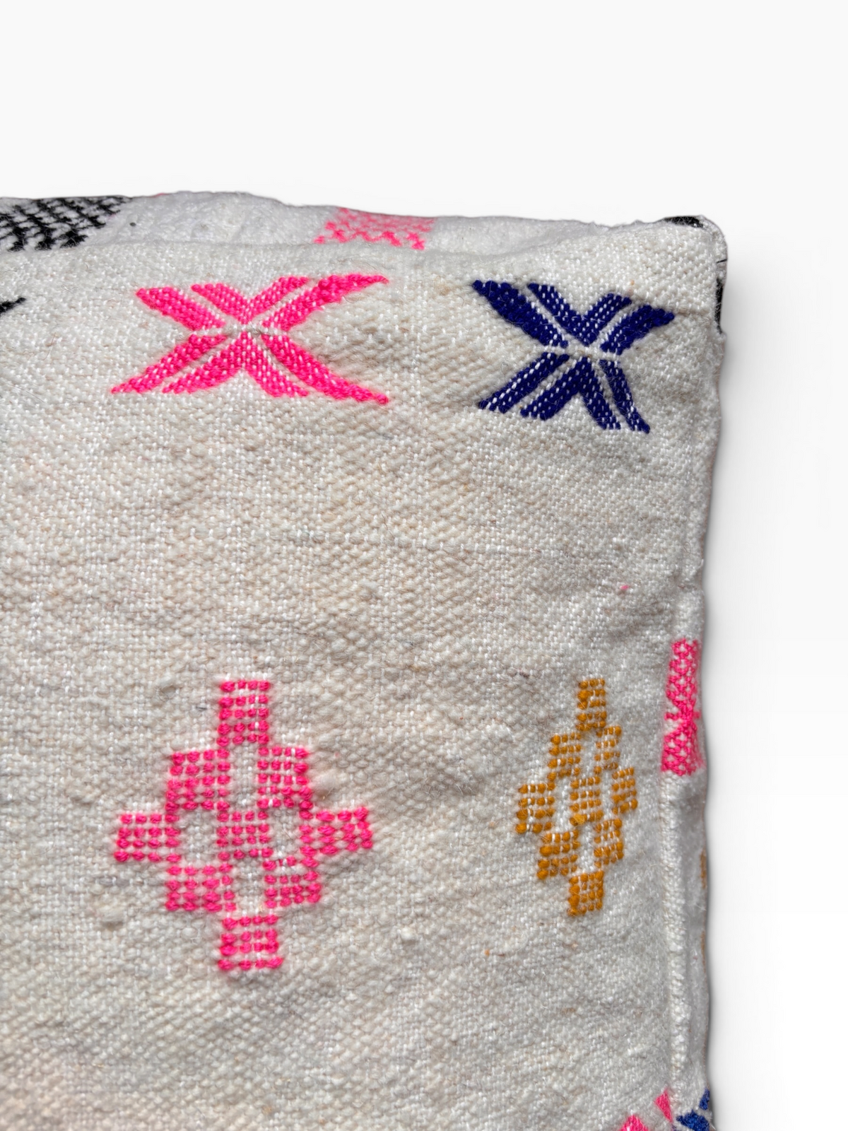 Nahaufnahme von LEY! Bodenkissen – Colorful Line – Lilina, mit lebhaften geometrischen Stickereien auf cremefarbenem Wollgrund.