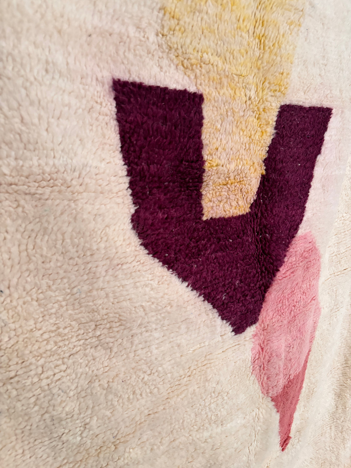 Nahaufnahme des traditionellen Berber-Musters auf beigem Wollteppich